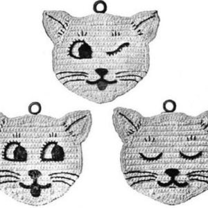 May include: Three crocheted cat face ornaments in a grayscale palette. Each cat face has a different expression: winking, wide-eyed, and sleeping. The ornaments have a small loop at the top for hanging.
