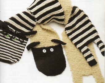 May include: A knitted scarf with a zebra and sheep design. The zebra portion is black and white striped, and the sheep portion is tan with a black face and white eyes.