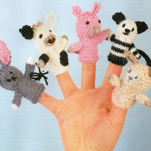 May include: A hand displaying five knitted finger puppets. The puppets include a gray bunny, a white cow with black spots, a pink pig, a black and white panda, and a beige sheep. Each puppet has detailed features and is designed to fit on a finger.