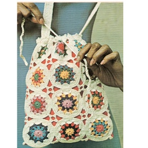 Pu&ograve; includere: Una borsa a cordoncino all'uncinetto con un motivo geometrico colorato. La borsa &egrave; realizzata con filato bianco con accenti rossi, arancioni, gialli, verdi, blu e viola.