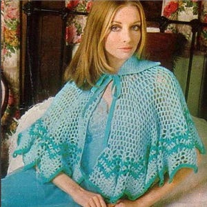 May include: A light blue crocheted cape with a scalloped edge and a tie closure. The cape features a detailed open weave design with a darker teal trim. The garment is worn over a light blue dress.