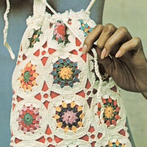 Pu&ograve; includere: Una borsa a cordoncino in crochet bianco con motivi circolari colorati. La borsa &egrave; realizzata in filato bianco e presenta una variet&agrave; di colori, tra cui rosso, rosa, blu, verde e giallo.