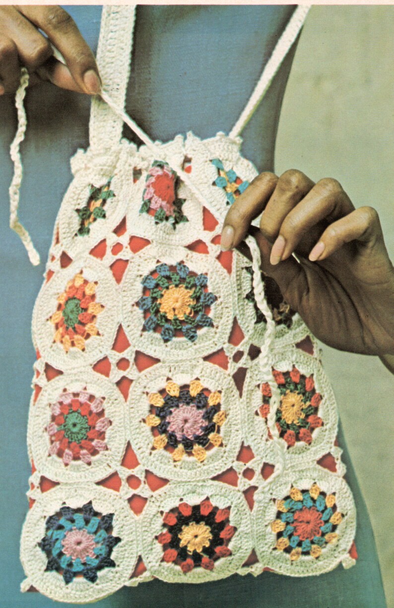 Pu&ograve; includere: Una borsa a cordoncino in crochet bianco con motivi circolari colorati. La borsa &egrave; realizzata in filato bianco e presenta una variet&agrave; di colori, tra cui rosso, rosa, blu, verde e giallo.