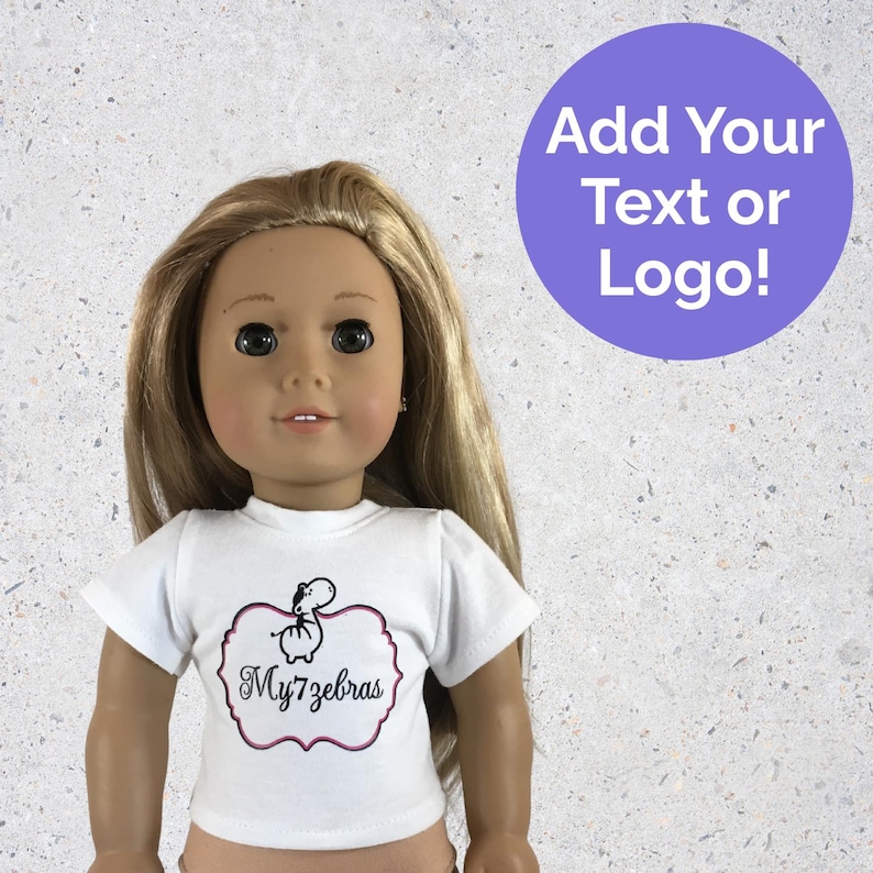 Peut inclure: Une poup&eacute;e blonde portant un t-shirt blanc avec un motif de z&egrave;bre de dessin anim&eacute; dans un cadre rose et noir. Le texte "My7zebras" est en dessous du z&egrave;bre. Un cercle violet avec le texte "Add Your Text or Logo!" est en arri&egrave;re-plan.