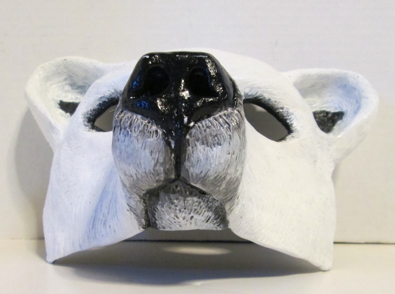 Puede incluir: M&aacute;scara de oso polar blanca con nariz negra y agujeros para los ojos. La m&aacute;scara est&aacute; hecha de un material suave y flexible, perfecta para un disfraz o una obra de teatro.