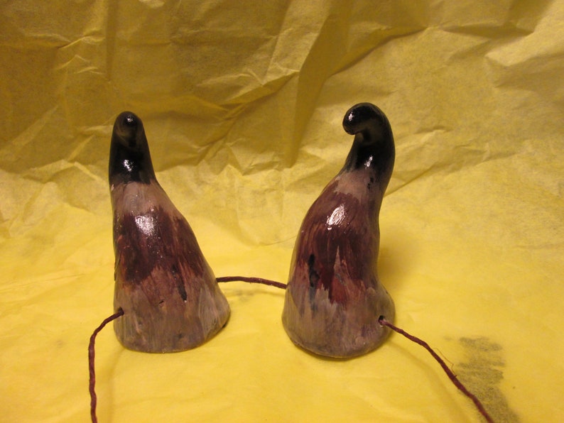 May include: Two black and purple devil horns with a brown string attached to the base of each horn.