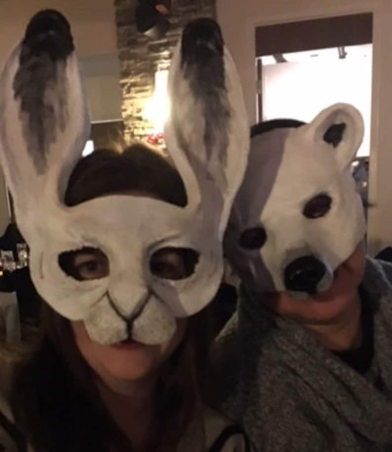 Puede incluir: Dos personas con m&aacute;scaras de animales. La persona de la izquierda lleva una m&aacute;scara de conejo blanca con orejas largas. La persona de la derecha lleva una m&aacute;scara de oso polar blanca.