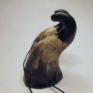 May include: A pair of black and brown horns with a distressed finish. The horns are attached to a black cord.