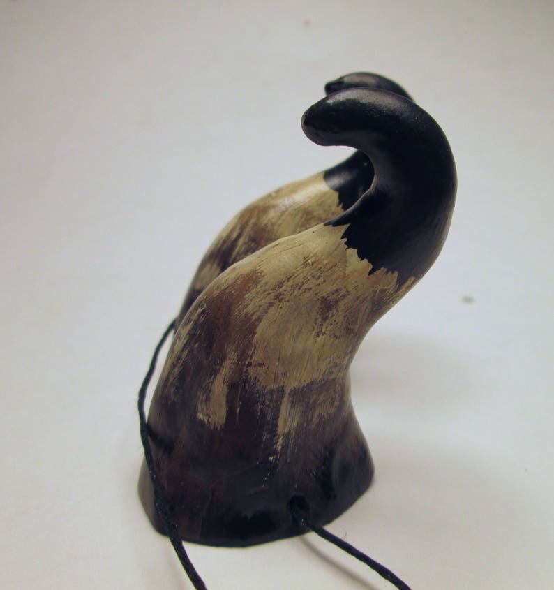 May include: A pair of black and brown horns with a distressed finish. The horns are attached to a black cord.
