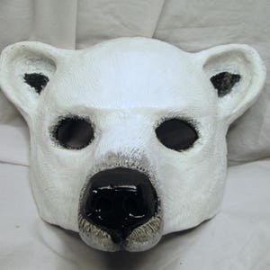 Puede incluir: M&aacute;scara de oso polar blanco con ojos y nariz negros. La m&aacute;scara est&aacute; hecha de un material suave y flexible, perfecta para un disfraz o una obra de teatro.