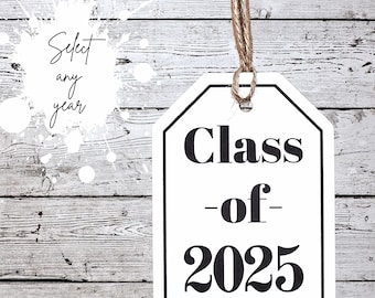 May include: White tag with black text that reads "Class of 2025" hanging from a brown twine string against a white wood background.