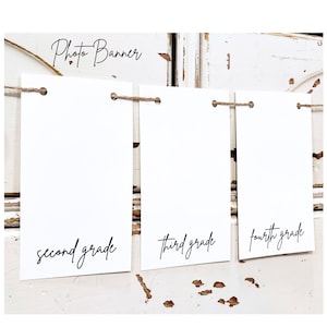 May include: Photo banner with three white cards strung together with twine. The cards have the words "second grade", "third grade", and "fourth grade" written on them in black cursive.