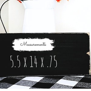 以下が含まれることがあります： 「Measurements 5.5 x 14 x .75」と白く書かれた黒い木製の看板です。