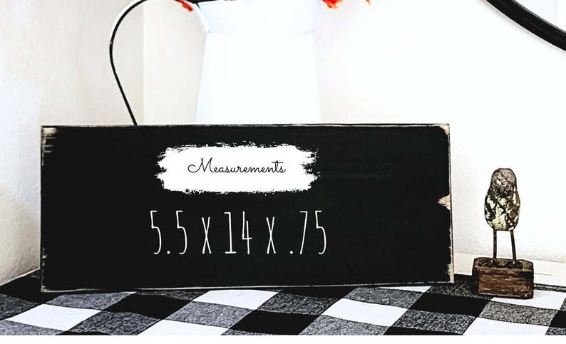 以下が含まれることがあります： 「Measurements 5.5 x 14 x .75」と白く書かれた黒い木製の看板です。