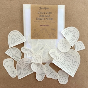 May include: A pack of iron-on embroidery transfer patches featuring rainbow designs, including a sun, a cloud with raindrops, and the words "love" and "hope".