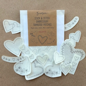 May include: A selection of heart-shaped embroidery transfer patches. The patches are white with black stitched outlines and various floral and vine designs. The packaging reads "Sweetpea Stick & Stitch Embroidery Transfer Patches".