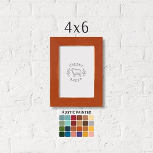 May include: A 4x6 inch rustic wooden picture frame with a distressed orange paint finish. The frame has a white mat and a print of a sheep with the text "Cheeky Sheep". The frame is shown against a white brick wall. A color palette of 24 colors is shown below the frame.