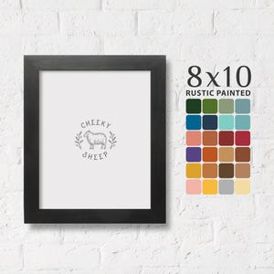 May include: Black wood frame with a white mat and a black and white illustration of a sheep with the text "Cheeky Sheep". The frame is 8x10 inches and is rustic painted.