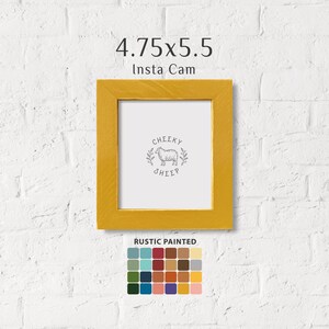 May include: A yellow wood picture frame with a white mat and a black and white illustration of a sheep with the text "Cheeky Sheep". The frame is 4.75 inches by 5.5 inches. The text "Insta Cam" is above the frame. A color palette of 25 different colors is below the frame with the text "Rustic Painted".