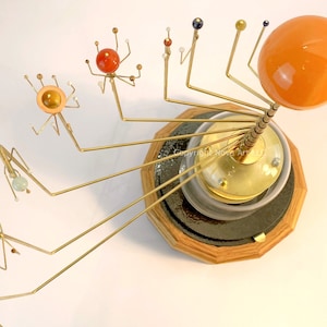 Wanderers Orrery: Solar system model in semi-precious stone planets; hardwood and solid brass gears. Heritage craftsmanship.