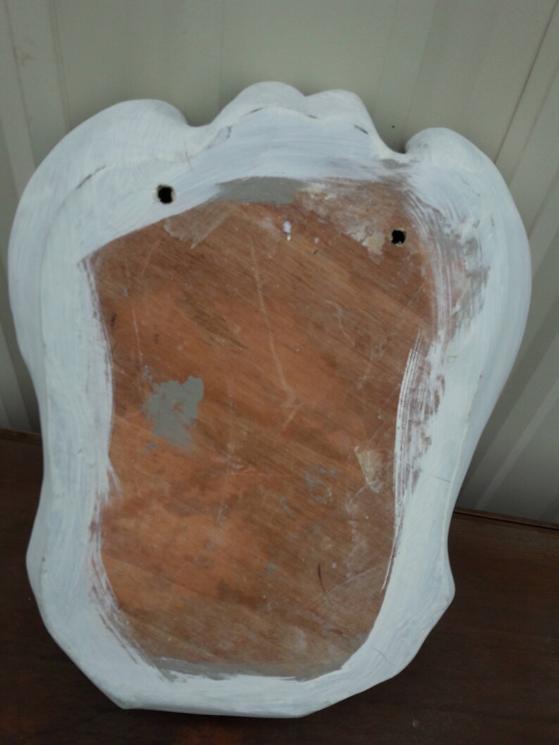 May include: White painted wooden plaque with a scalloped edge and two holes for hanging. The back of the plaque is made of wood and has a natural finish.
