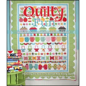 May include: A book titled "Quilty Fun: Lessons in Scrappy Patchwork by Lori Holt" featuring a colorful patchwork quilt with a variety of designs, including houses, cups, and butterflies. The book also includes the Bee in my Bonnet Row Along Quilt and 10 more Quilty Projects.