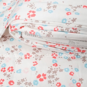 May include: White fabric with a floral print in shades of pink, blue, and brown. The fabric is folded and the label "CLOUD9 FABRICS" is visible.