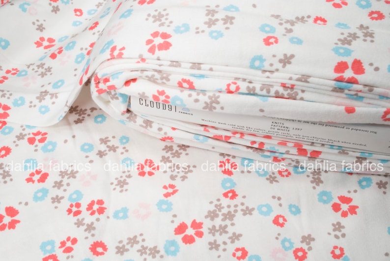 May include: White fabric with a floral print in shades of pink, blue, and brown. The fabric is folded and the label "CLOUD9 FABRICS" is visible.