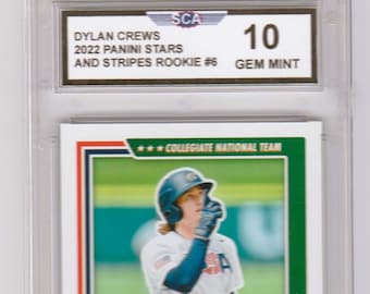 Puede incluir: Una tarjeta de béisbol con Dylan Crews, un jugador de béisbol del Equipo Nacional Colegiado. La tarjeta está calificada como 10 Gem Mint por la Sportscard Guaranty Corporation (SCA).