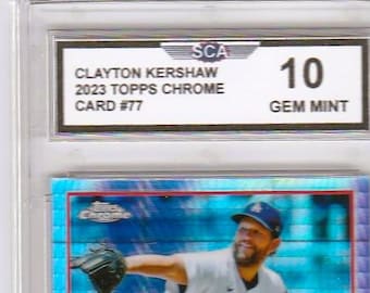 May include: A graded baseball card featuring Clayton Kershaw in a Los Angeles Dodgers uniform. The card is from the 2023 Topps Chrome series, card #77, and is graded a 10 Gem Mint by SCA. The card is encased in a clear protective holder.