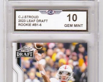 May include: A white and black football card featuring a football player throwing a football. The card is graded 10 Gem Mint by SCA. The card features the text "C.J. Stroud 2023 Leaf Draft Rookie #B1-6" and "C.J. Stroud".