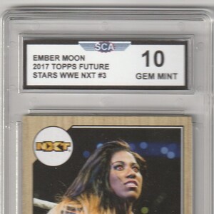 May include: A GEM MINT Ember Moon trading card from the 2017 Topps Future Stars WWE NXT #3 series. The card features a color image of Ember Moon in a wrestling ring. The card is encased in a protective plastic holder.