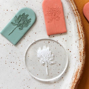 May include: Four different stamps with a floral design. The stamps are in the shape of an arch and are made of a soft, pliable material. The stamps are in various colors, including green, pink, and white.