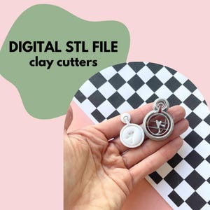May include: Two silver clay cutters are held in a hand. One is a solid white shape, the other has a cut-out design. The text "DIGITAL STL FILE clay cutters" is in the background, with a black and white checkered pattern.