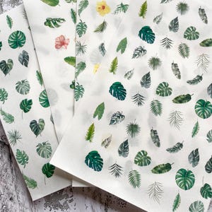 May include: Four sheets of white paper are decorated with diverse green tropical leaf and flower designs. The leaves vary in shape and size, with some featuring intricate details. A few pink and yellow flowers are also scattered across the sheets.
