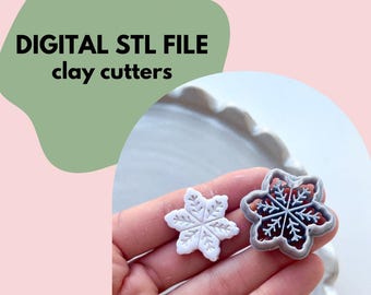 May include: Two snowflake-shaped clay cutters, one white and one with a gray border and red interior, are held in a hand. The image includes the text "DIGITAL STL FILE clay cutters" in black letters on a green shape.