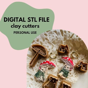 Op de afbeelding: Digitale STL-bestanden voor klei-uitstekers, met bruine kunststof mallen in de vorm van paddenstoelen en muizen. Twee afgewerkte oorbellen tonen een muis in een groene jas onder een rood-witte paddenstoelhoed met goudkleurige ringen.