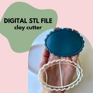 May include: A teal oval clay cutter with a scalloped edge is held in a hand, next to a white oval cutter. The text "DIGITAL STL FILE clay cutter" is in the upper left corner. The background is a light pink and green.