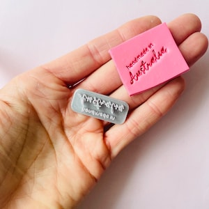 May include: Two rubber stamps, one pink and one grey. The pink stamp says "handmade in Australia". The grey stamp says "engraved by Nauquagon".