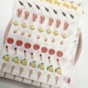 May include: Sheets of stickers featuring watercolor illustrations of Italian food items. The stickers include pasta, skewers, lobster, ravioli, wine glasses, tomatoes, cannoli, lemons, and ice cream cones. The stickers are on a white background.