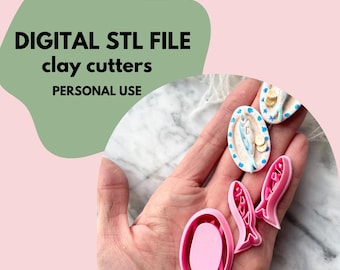 May include: Pink clay cutters in various shapes, including an oval and fish designs, are displayed in a hand. The image also features finished clay pieces with blue and yellow accents. Text on the image reads "DIGITAL STL FILE clay cutters PERSONAL USE."