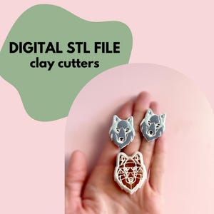 Puede incluir: Tres cortadores de arcilla con forma de lobo. Dos son grises con detalles blancos, y uno es blanco con un diseño abierto. La imagen incluye el texto "DIGITAL STL FILE clay cutters" sobre una forma verde sobre fondo rosa.