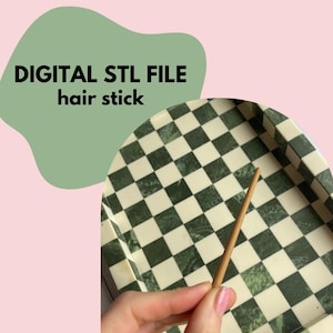 Puede incluir: Un palillo para el pelo de color marrón claro se sostiene sobre un fondo a cuadros verde y blanco. El texto "DIGITAL STL FILE hair stick" se muestra en una forma verde sobre un fondo rosa. El palillo para el pelo parece ser de madera.