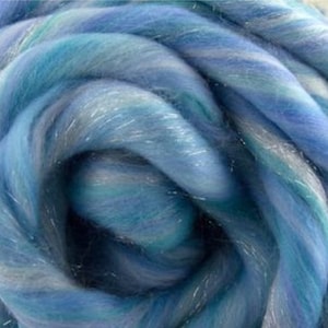 K&ouml;nnte beinhalten: Nahaufnahme eines B&uuml;ndels blauer, wei&szlig;er und silberner Merinowolle mit einem dezenten Schimmer.