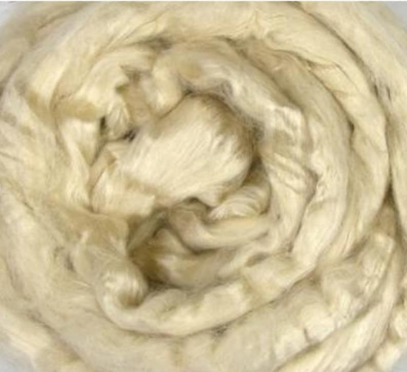 Peut inclure: Gros plan sur un tas de fibres de soie blanches cr&eacute;meuses. Les fibres sont douces et moelleuses, et elles sont dispos&eacute;es en un motif tourbillonnant.