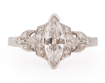 Könnte beinhalten: Ein silberner Ring mit einem Marquise-Diamanten, der in einem zarten floralen Design gefasst ist.