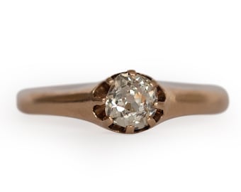 Puede incluir: Un anillo de oro con un solo diamante redondo y transparente engastado en garras.