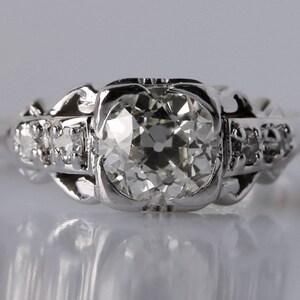 May include: A silver engagement ring with a large, round, clear diamond center stone and smaller diamonds set in the band.