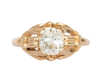 Könnte beinhalten: Ein goldener Ring mit einem großen, klaren, runden Diamanten, der in einem filigranen, verzierten Design gefasst ist.