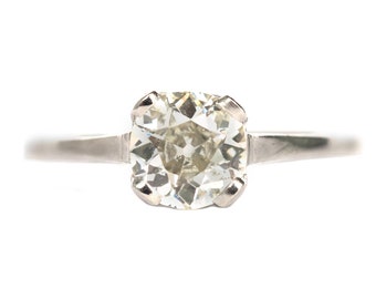 May include: A silver ring with a large, clear, round diamond.